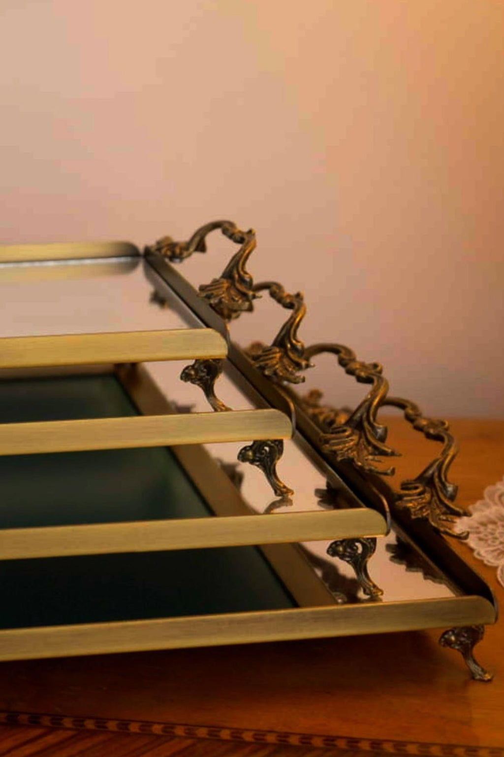 Eskitme detaylı zarif kulplu büyük metal tepsi yansıtıcı yüzeyli, masada dekoratif sunum.